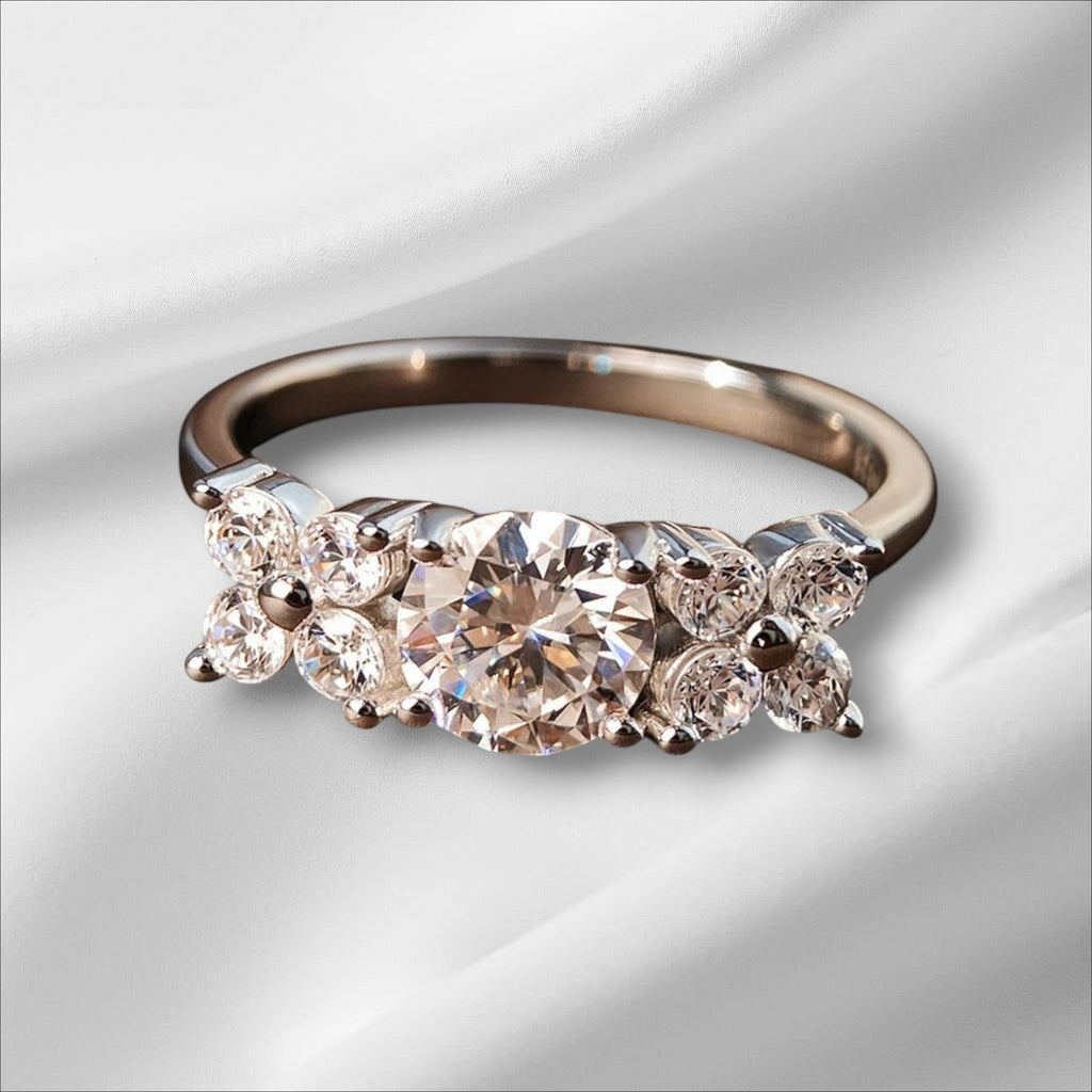 Bee-Bees 1ct D VVS1 Moissanite engagement ring in 925 silver with 18k white gold plating. Round brilliant cut center stone with cluster accents.
