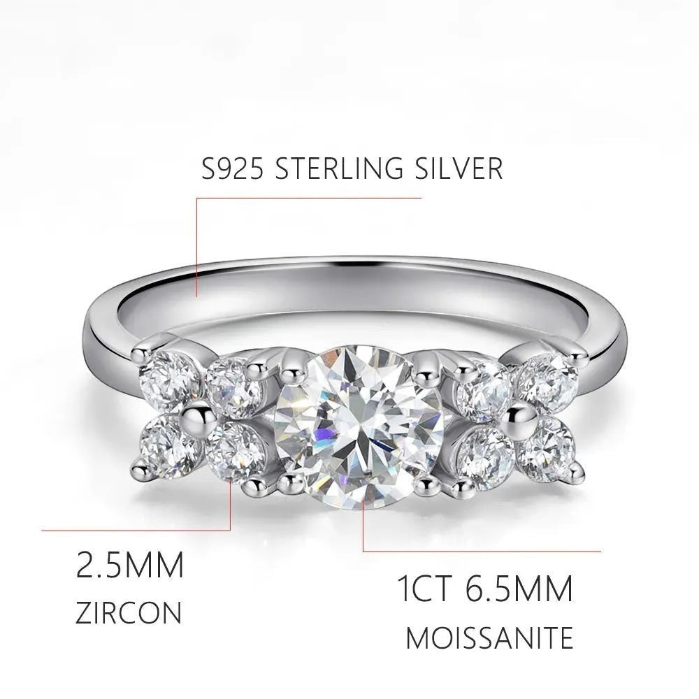 Bee-Bees 1ct D VVS1 Moissanite engagement ring in 18k white gold plated 925 silver with round brilliant cut center stone and side stones.