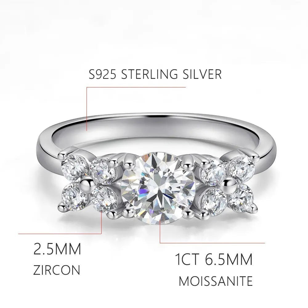 Bee-Bees 1ct D VVS1 Moissanite engagement ring in 18k white gold plated 925 silver with round brilliant cut center stone and side stones.