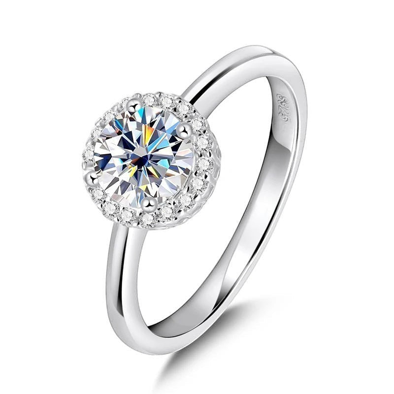 Bee-Bees 1ct round brilliant cut moissanite engagement ring in sterling silver with 18k white gold plating and halo of small stones.