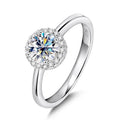 Bee-Bees 1ct round brilliant cut moissanite engagement ring in 925 sterling silver with 18k white gold plating and halo of small stones.