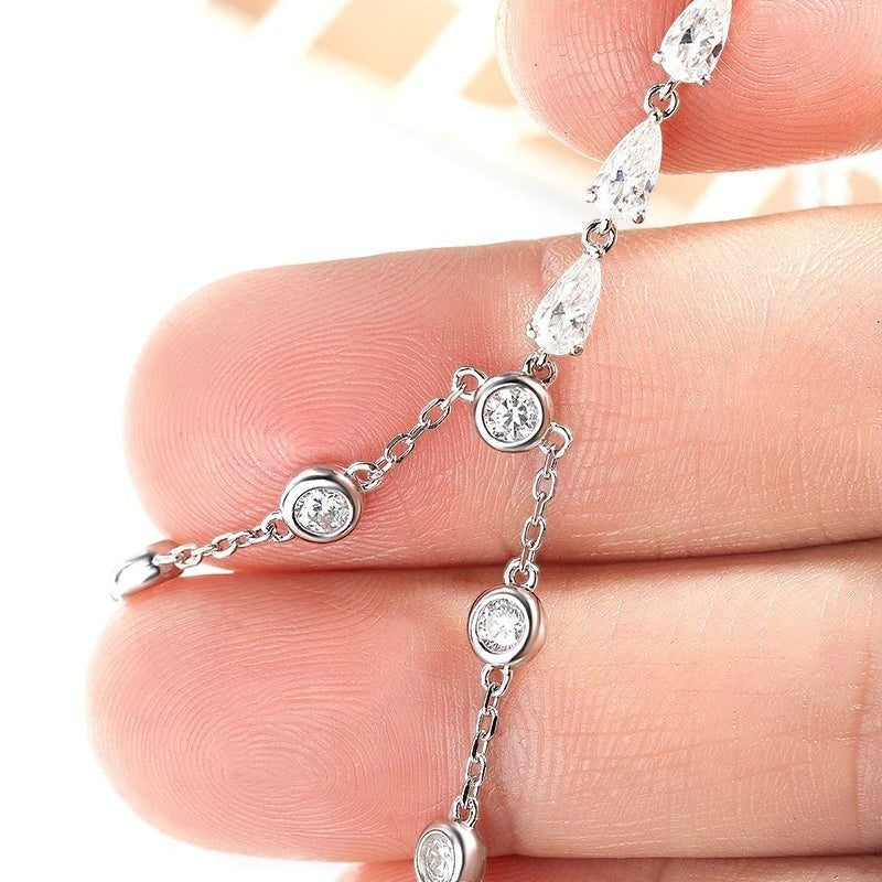 Bee-Bees 925 silver adjustable chain bracelet with 3mm round and pear-cut moissanite stones in a bubble setting.