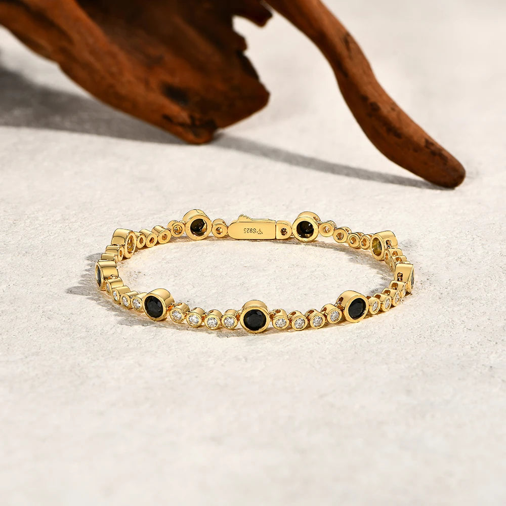 Bee-Bees black moissanite tennis bracelet in 18K gold-plated S925 sterling silver with round stones on a textured surface