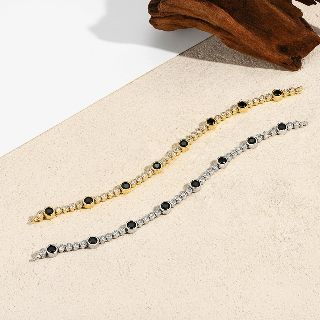 Bee-Bees black moissanite tennis bracelets in 18K gold-plated and S925 sterling silver on a textured surface.