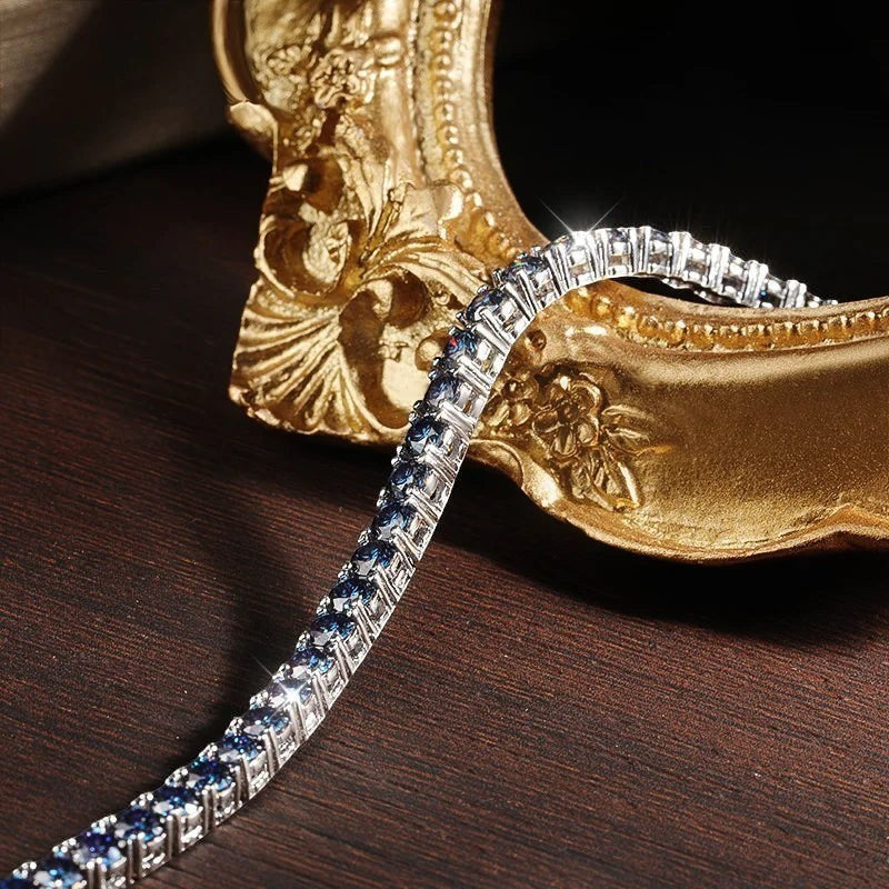 Bee-Bees blue moissanite tennis bracelet in S925 sterling silver with 18k white gold plating. Features VVS1 clarity stones.