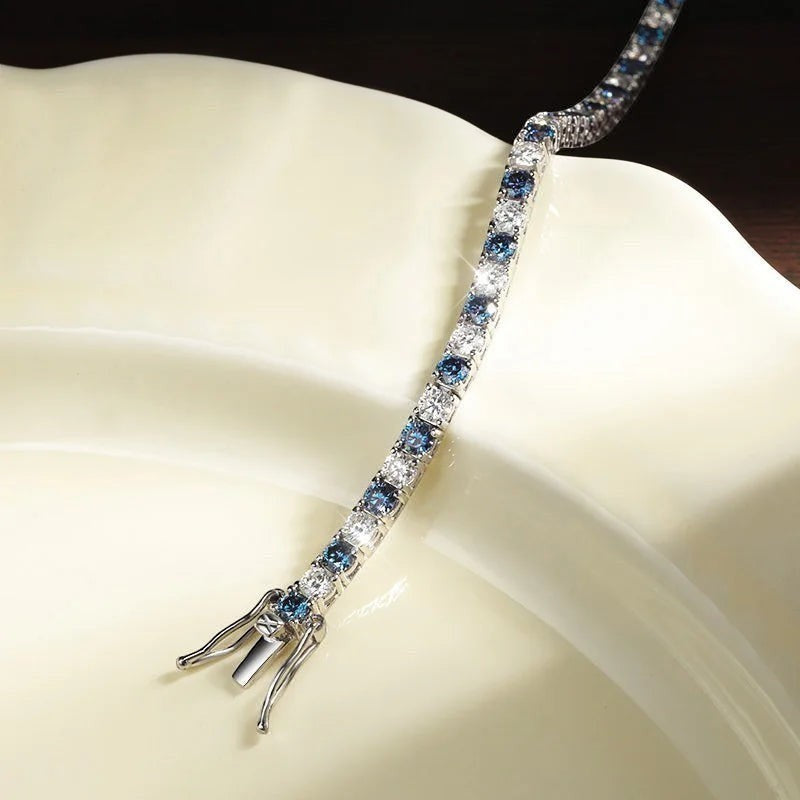 Bee-Bees blue and clear moissanite tennis bracelet in sterling silver with white gold plating. Features a secure clasp.