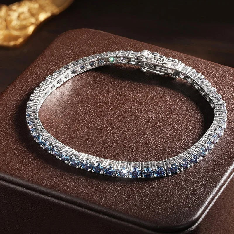 Bee-Bees blue moissanite tennis bracelet crafted from S925 sterling silver with 18k white gold plating. Features round-cut blue stones.