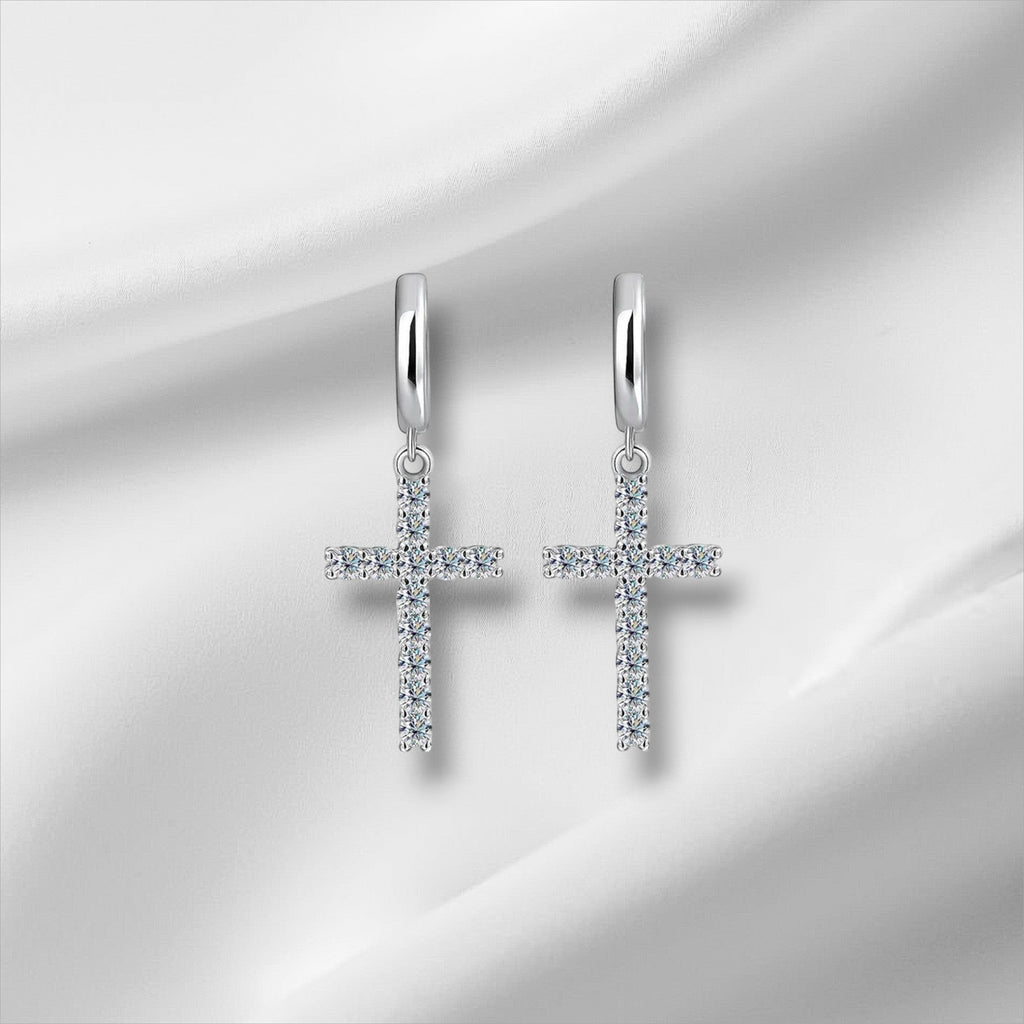 Bee-Bee's sterling silver hoop earrings with dangling cross pendants encrusted with clear moissanite stones.