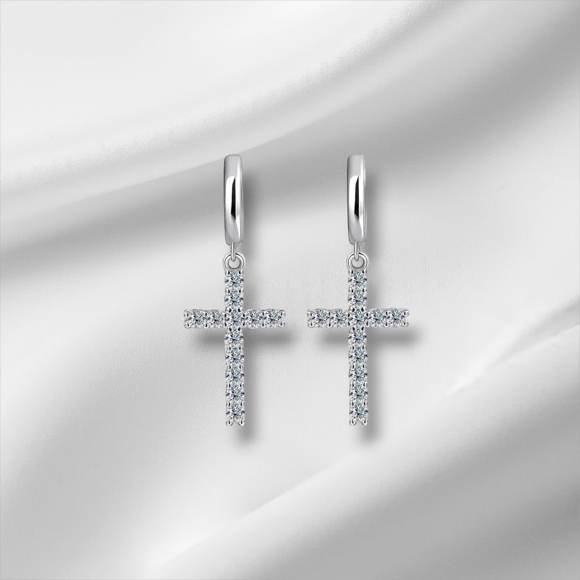 Bee-Bee's sterling silver hoop earrings with dangling cross pendants encrusted with clear moissanite stones.