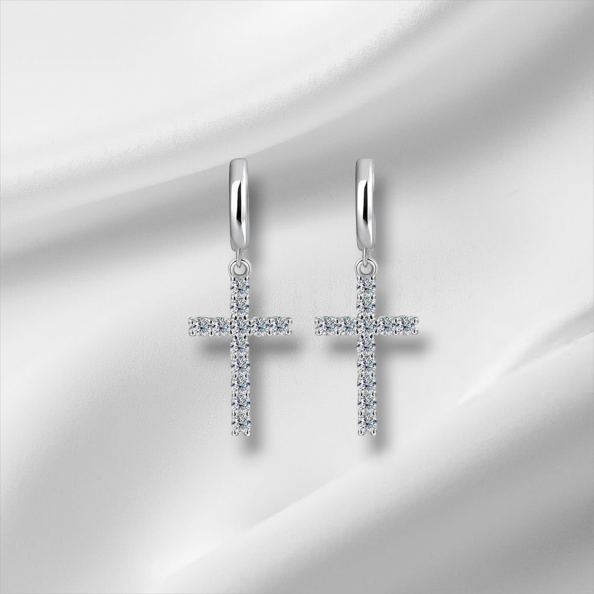 Bee-Bee's sterling silver hoop earrings with dangling cross pendants encrusted with clear moissanite stones.