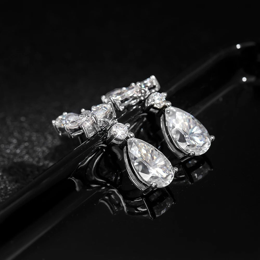 Bee-Bees Emerald cut moissanite drop earrings in sterling silver with 18k gold plating. D color, VVS1 clarity, 8.8ct total weight.
