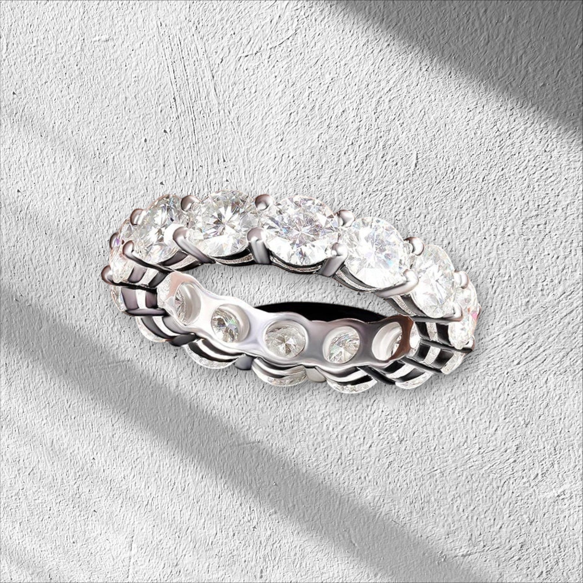 Bee-Bees full eternity band with 7.0 CTW round cut moissanite stones in 925 sterling silver with 18K white gold plating.