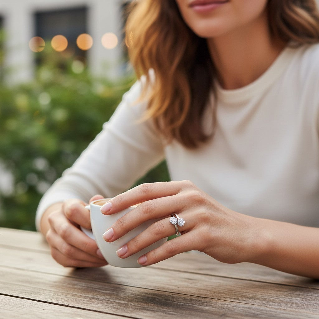 Bee-Bees flower moissanite wedding ring with 2.5mm stones on a woman's hand holding a white coffee cup outdoors.