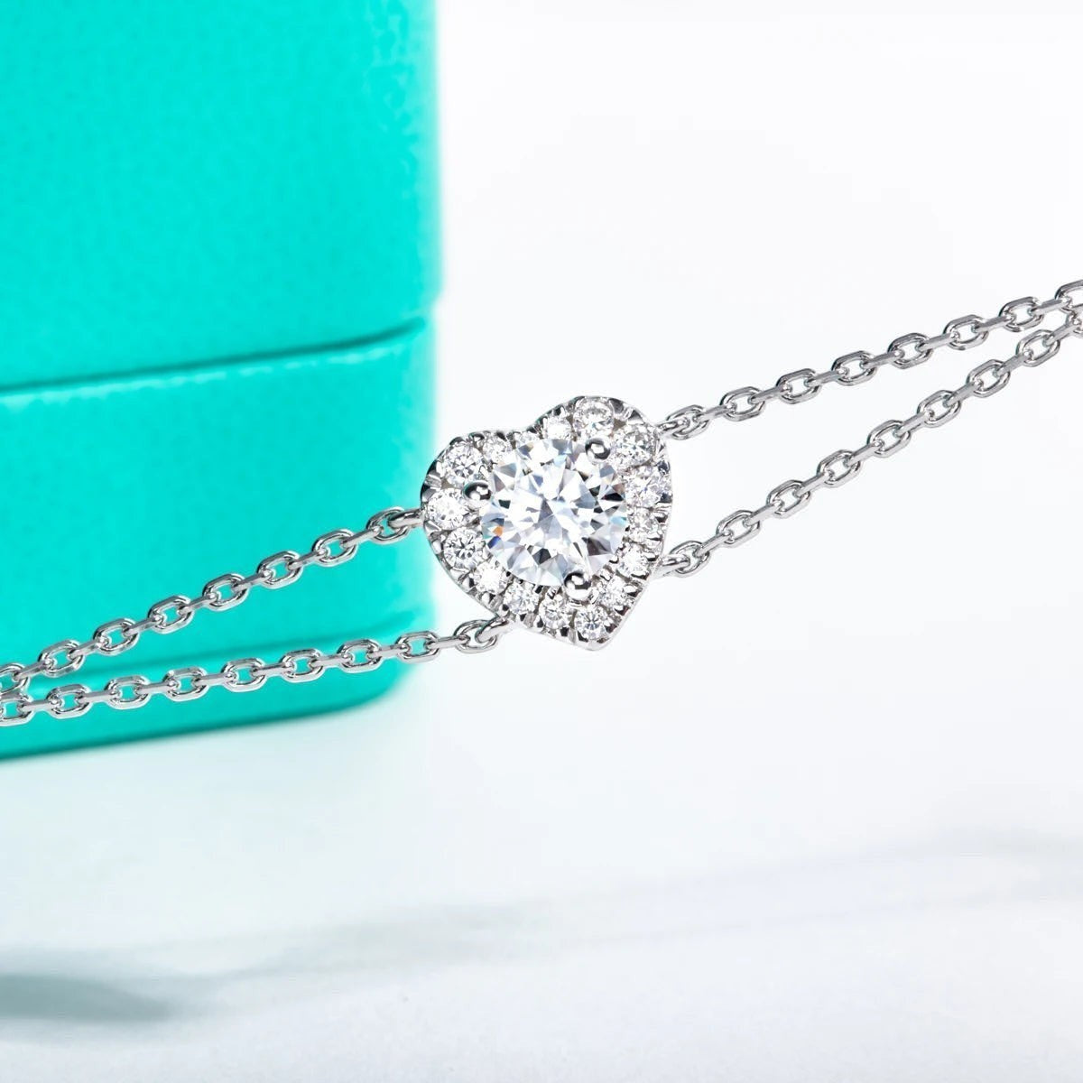 Bee-Bees 1ct heart moissanite bracelet in sterling silver with 18k gold plating. Features a D VVS1 heart-shaped stone surrounded by smaller stones.