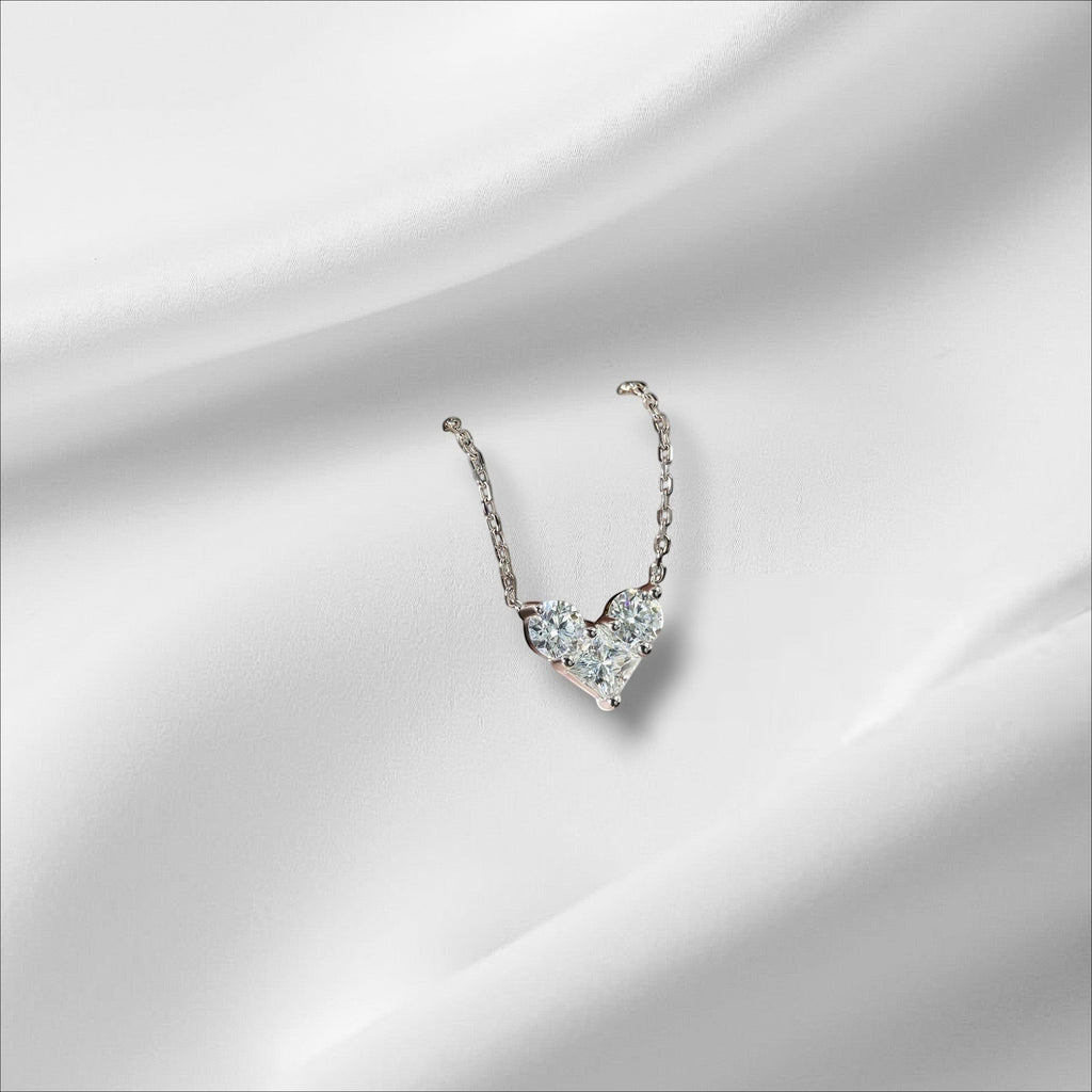 Bee-Bees sterling silver necklace with a heart-shaped pendant made of round and princess-cut moissanite stones.