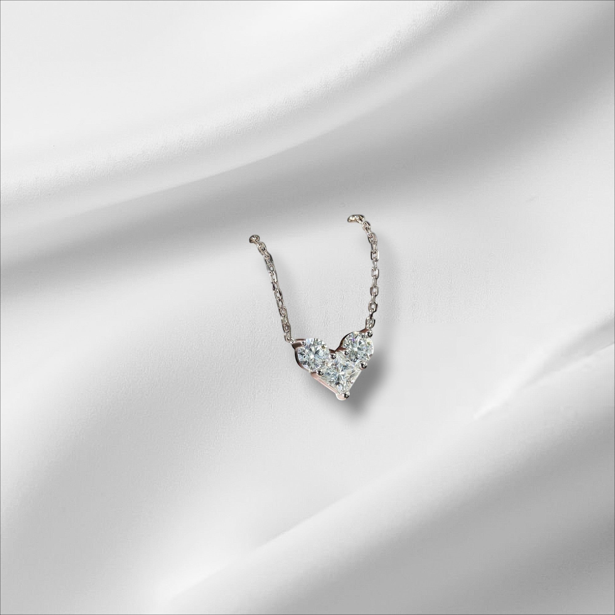 Bee-Bees sterling silver necklace with a heart-shaped pendant made of round and princess-cut moissanite stones.