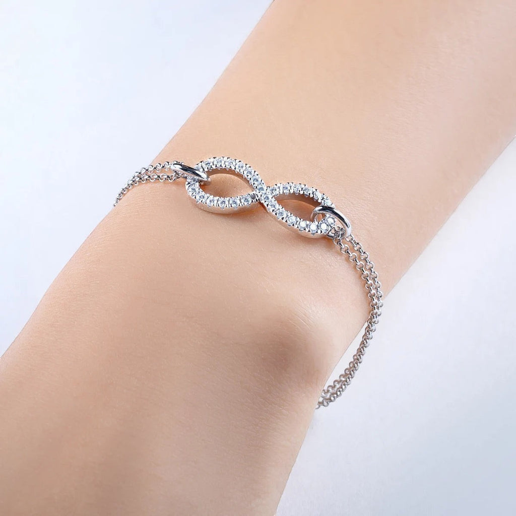 Bee-Bee's Sterling silver bracelet with infinity symbol adorned with moissanite stones, 18k gold plated, adjustable chain.