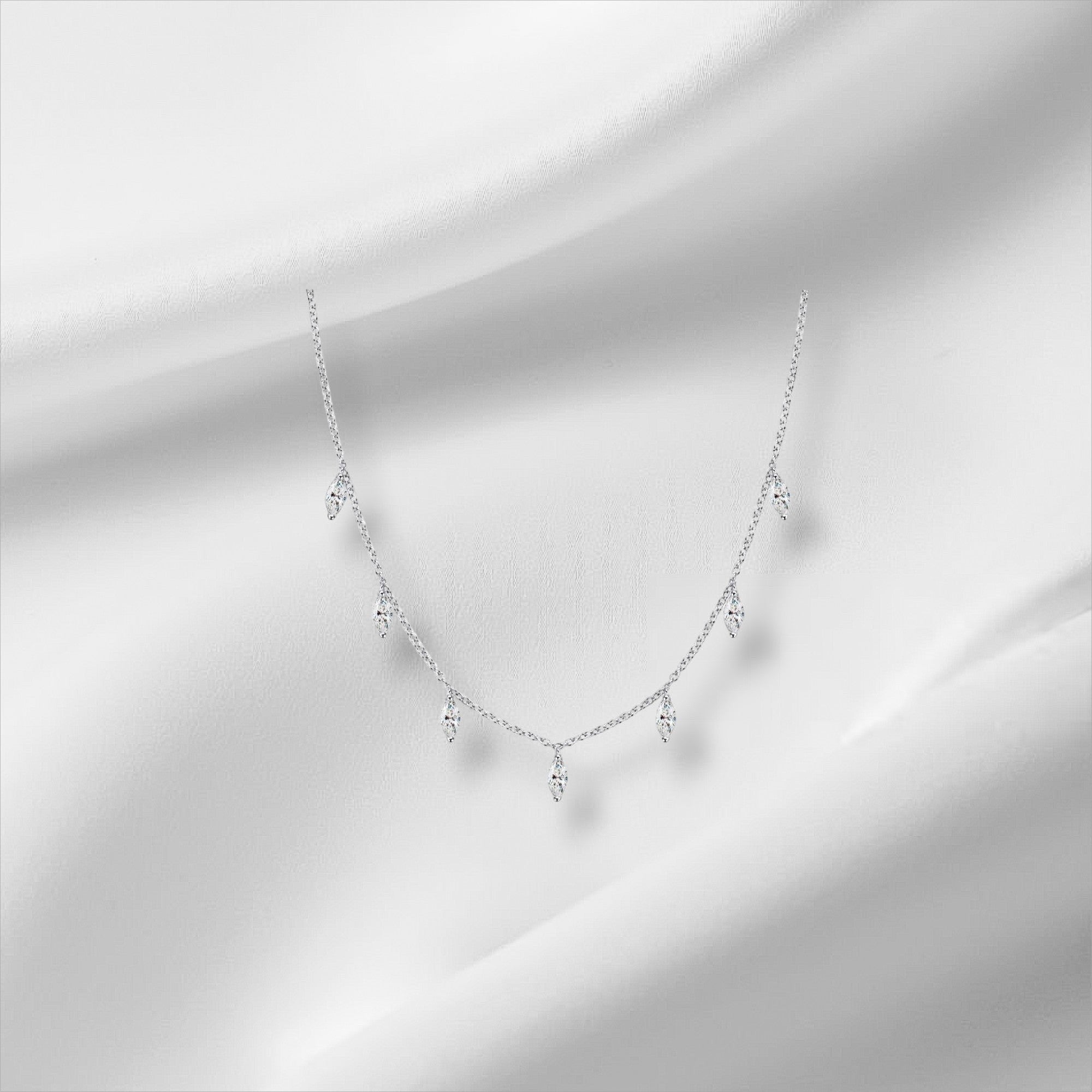 Bee-Bees sterling silver necklace with multiple marquise-cut moissanite stones dangling from a delicate chain.