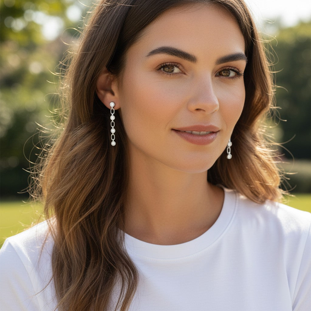 Bee-Bees dainty moissanite chain tassel earrings in sterling silver worn by a woman with long brown hair.