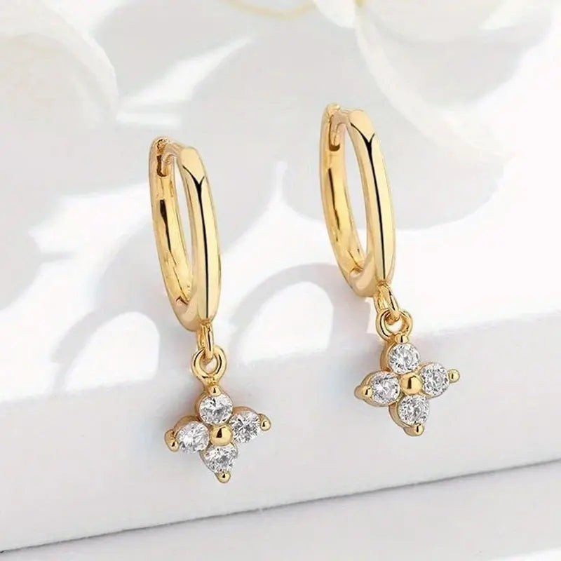 Bee-Bee's gold-plated sterling silver hoop earrings with dangling clover charms set with D-color moissanite stones.