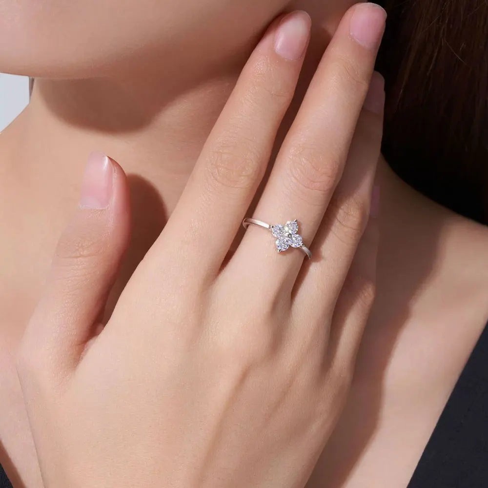 Bee-Bees sterling silver ring featuring a sparkling D-color moissanite four-leaf clover design on a woman's finger.