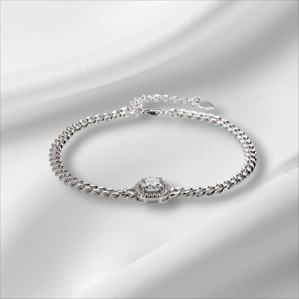 Bee-Bees Moissanite Cuban link bracelet in sterling silver with 18k white gold plating and a central halo-set round brilliant moissanite stone.