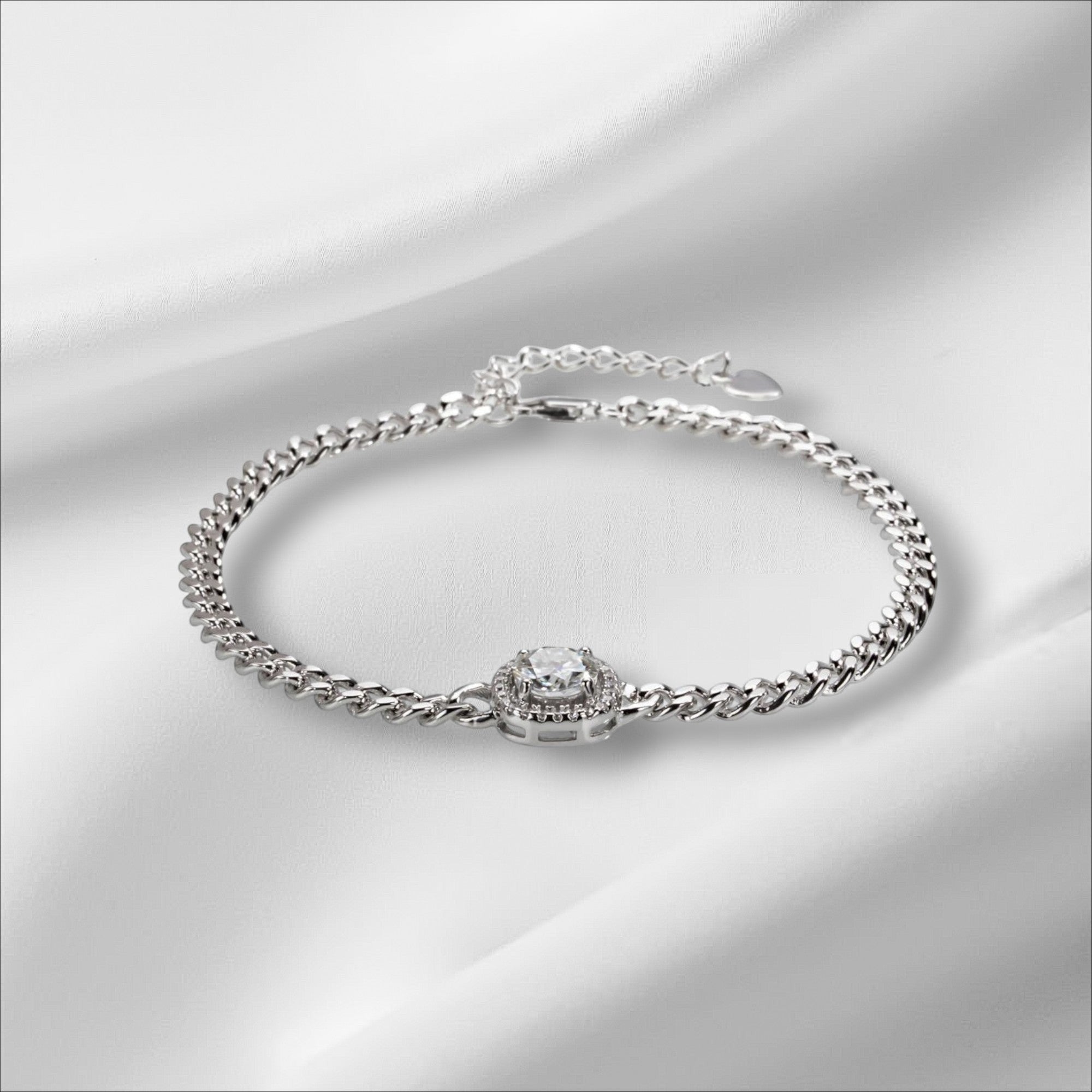 Bee-Bees Moissanite Cuban link bracelet in sterling silver with 18k white gold plating and a central halo-set round brilliant moissanite stone.