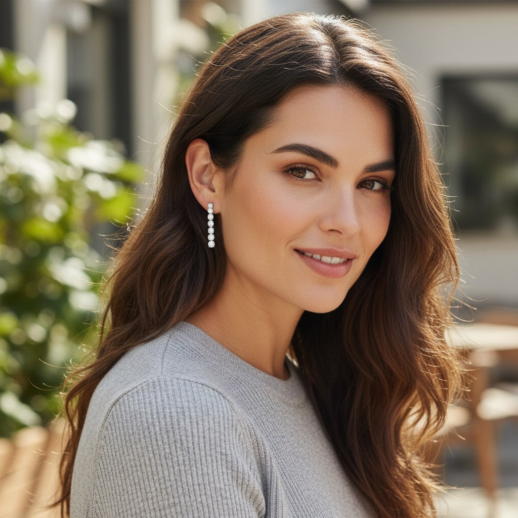 Bee-Bees D VVS1 moissanite drop earrings featuring 14 sparkling stones on a woman with long wavy brown hair