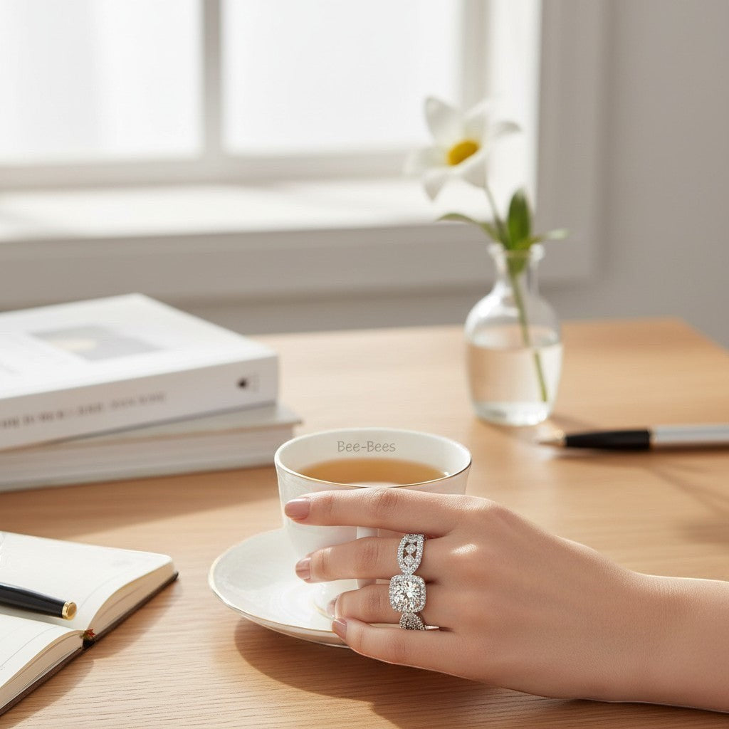 Bee-Bees 1ct D VVS1 Moissanite engagement ring with 18k white gold plating on sterling silver, featuring a large solitaire stone and halo band.