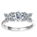 Bee-Bees 1ct D VVS1 Moissanite engagement ring in 925 silver with 18k white gold plating. Round brilliant cut center stone with smaller stones on band.