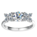 Bee-Bees 1ct D VVS1 Moissanite engagement ring in 925 silver with 18k white gold plating. Round brilliant cut center stone with smaller stones on band.