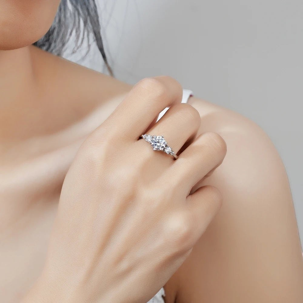 Bee-Bees 1ct round moissanite engagement ring in s925 sterling silver with 18k white gold plating. Classic solitaire style with 6-prong setting.