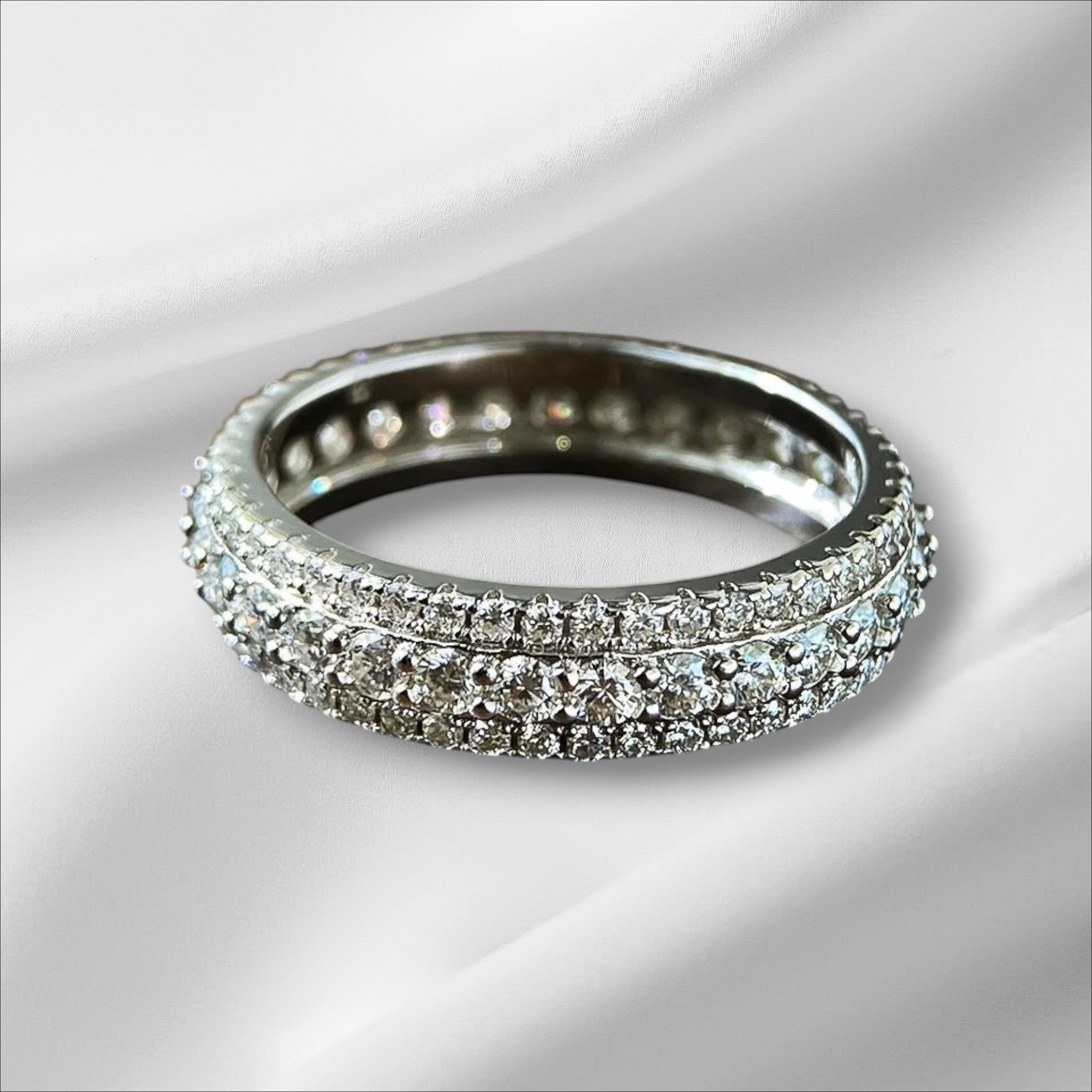 Bee-Bees Moissanite eternity band ring in s925 Sterling Silver with 18k white gold plating. Features round-cut stones in a shared prong setting.