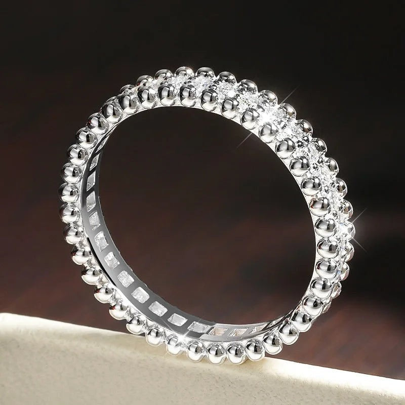 Bee-Bees VVS1 Moissanite full eternity band in sterling silver with 18k white gold plating. Features a beaded edge and channel-set stones.
