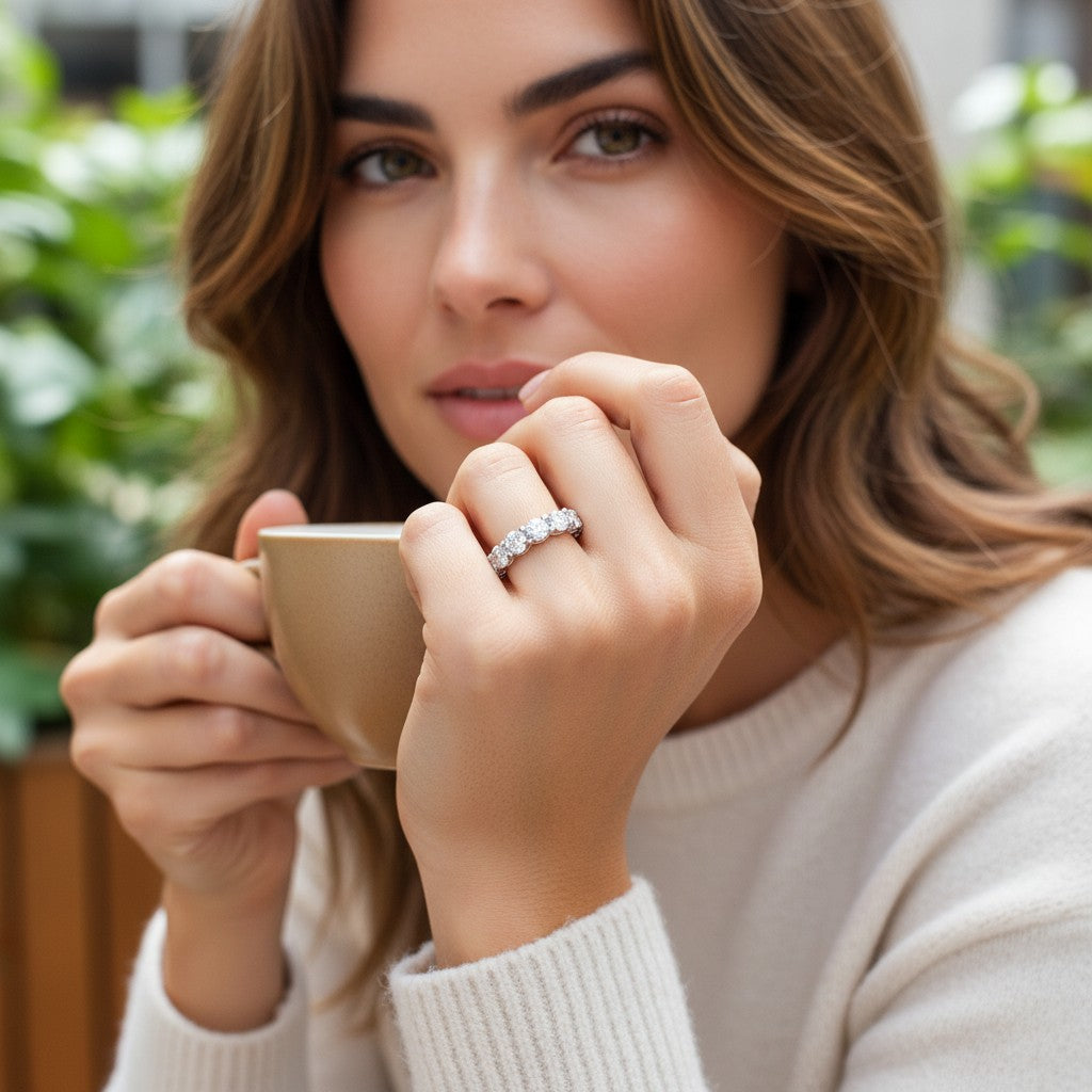 Woman wearing a Bee-Bees 7ctw full eternity moissanite band in 925 sterling silver while holding a coffee cup.