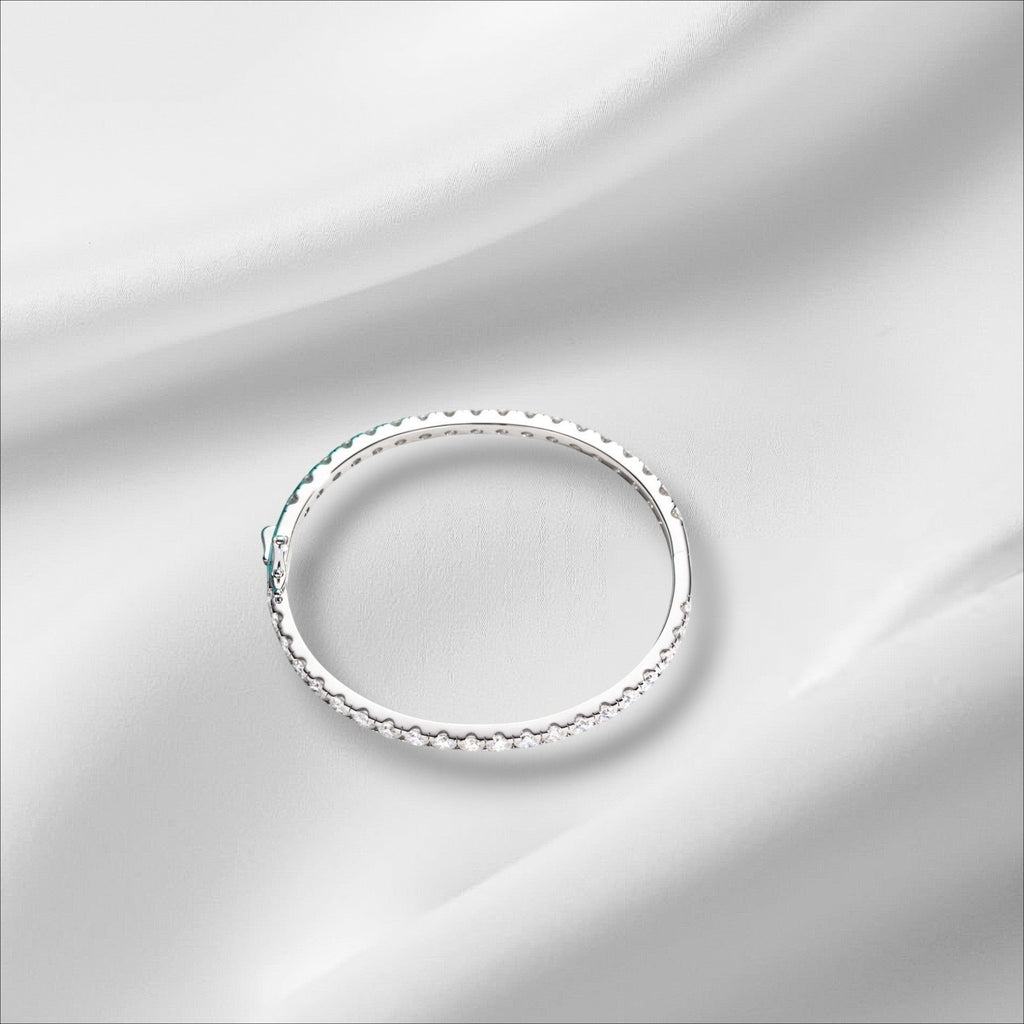 Bee-Bees 11.7ctw Moissanite eternity bangle in sterling silver with 18k white gold plating. Features 4mm round-cut stones and a secure clasp.