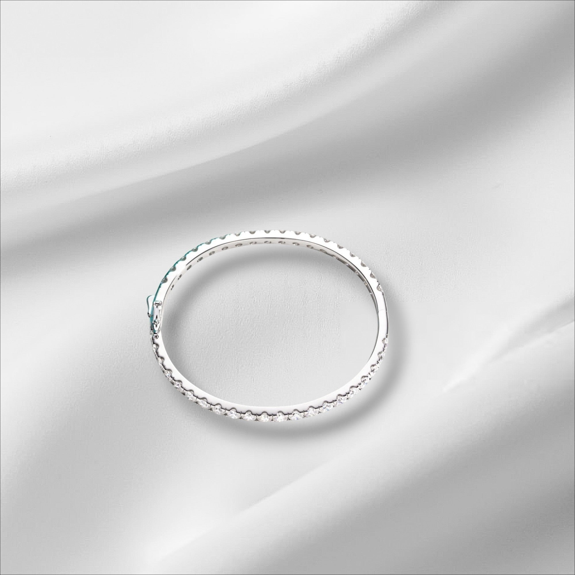 Bee-Bees 11.7ctw Moissanite eternity bangle in sterling silver with 18k white gold plating. Features 4mm round-cut stones and a secure clasp.