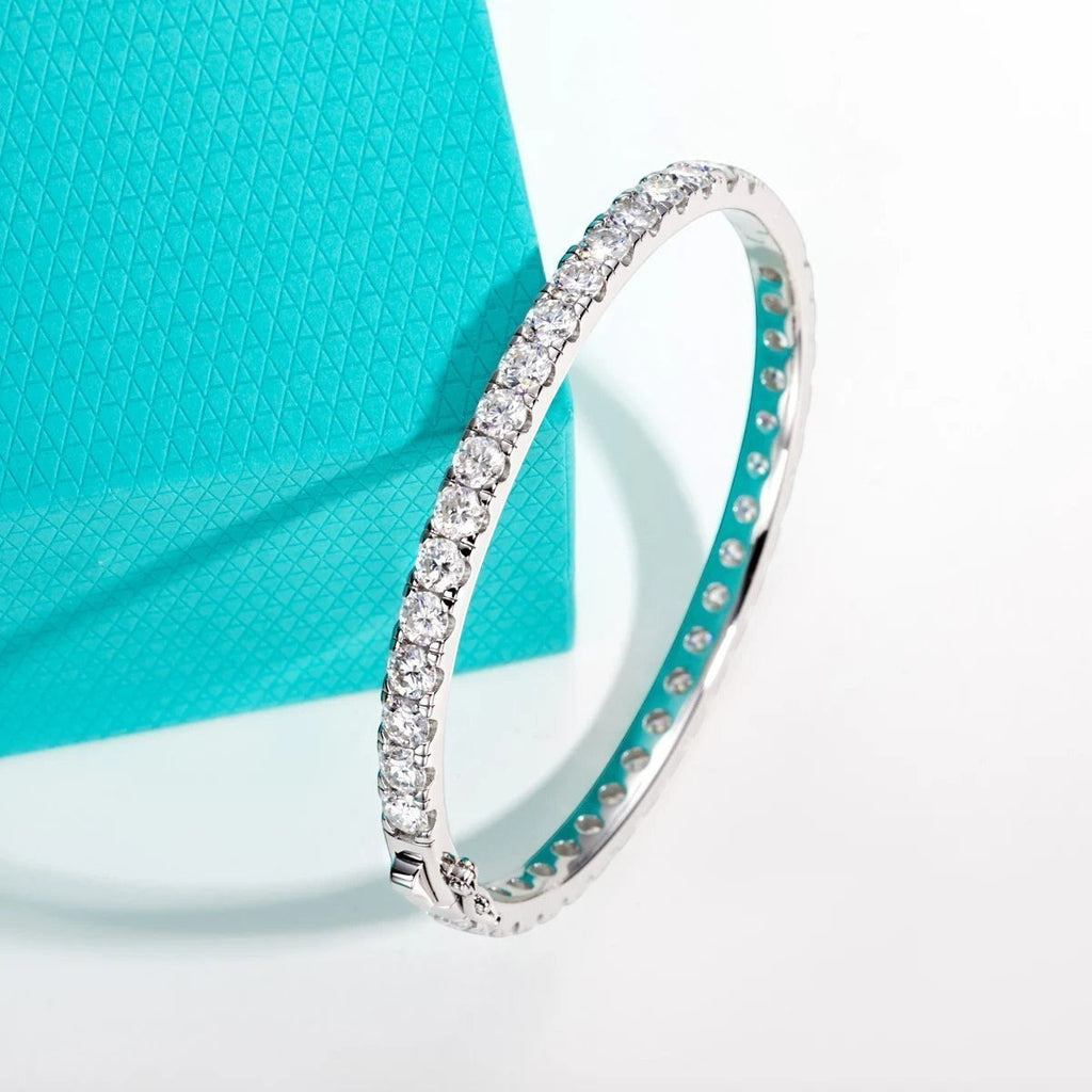 Bee-Bee's 11.7ctw Moissanite eternity bangle in sterling silver with 18k white gold plating. Features 4mm round-cut stones and a secure clasp.