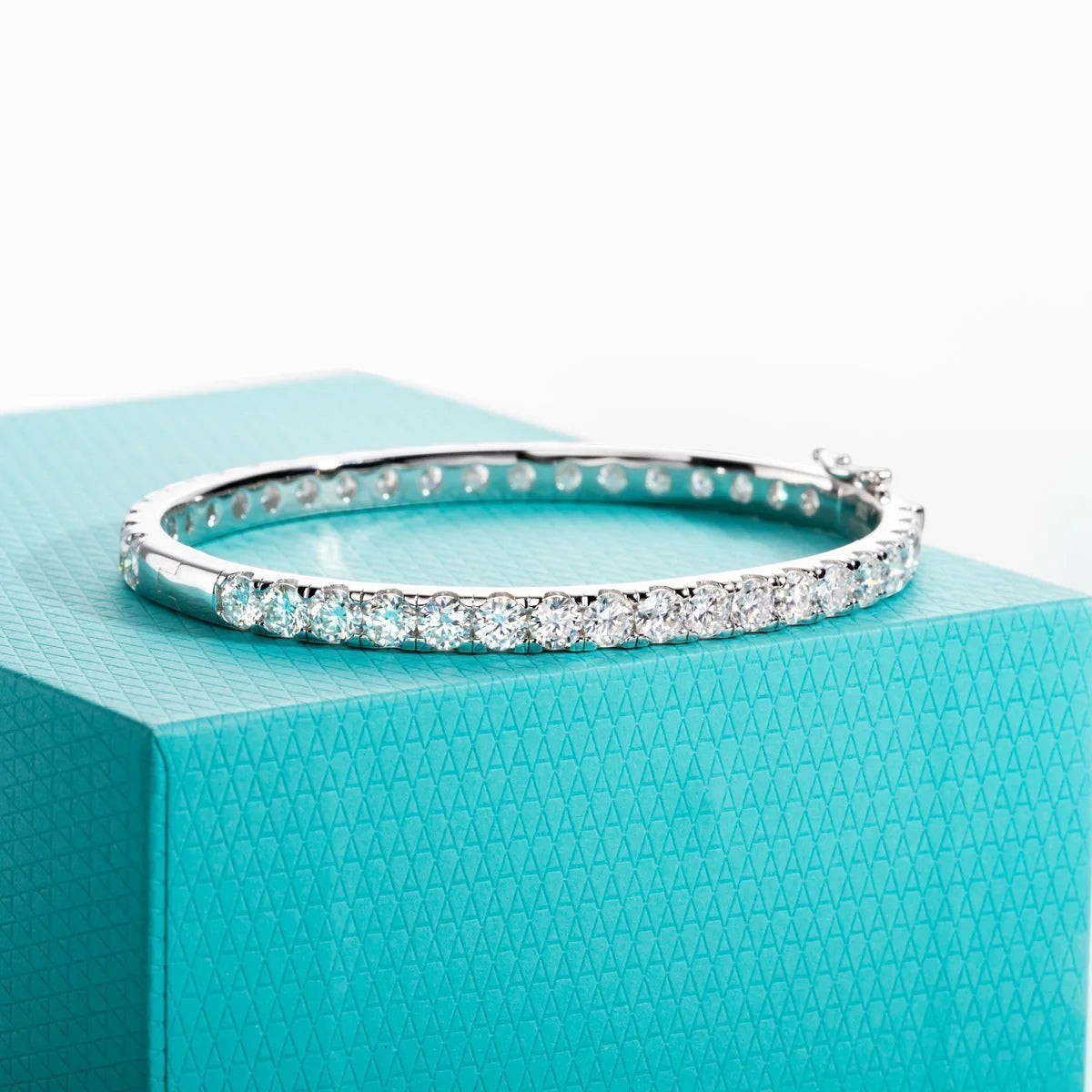 Bee-Bee's 11.7ctw Moissanite eternity bangle in sterling silver with 18k white gold plating. Features 4mm round-cut stones.