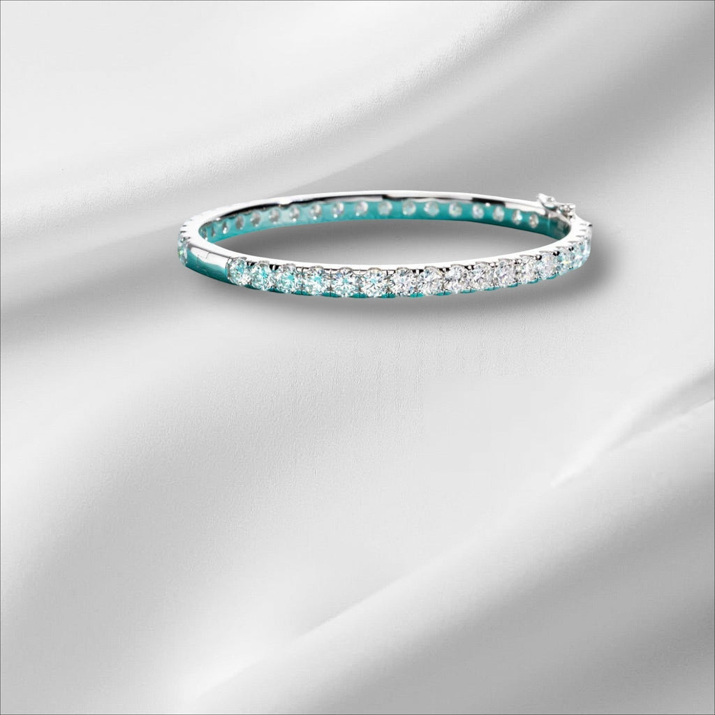 Bee-Bee's 11.7ctw Moissanite eternity bangle in sterling silver with 18k white gold plating. Features 4mm round-cut stones.