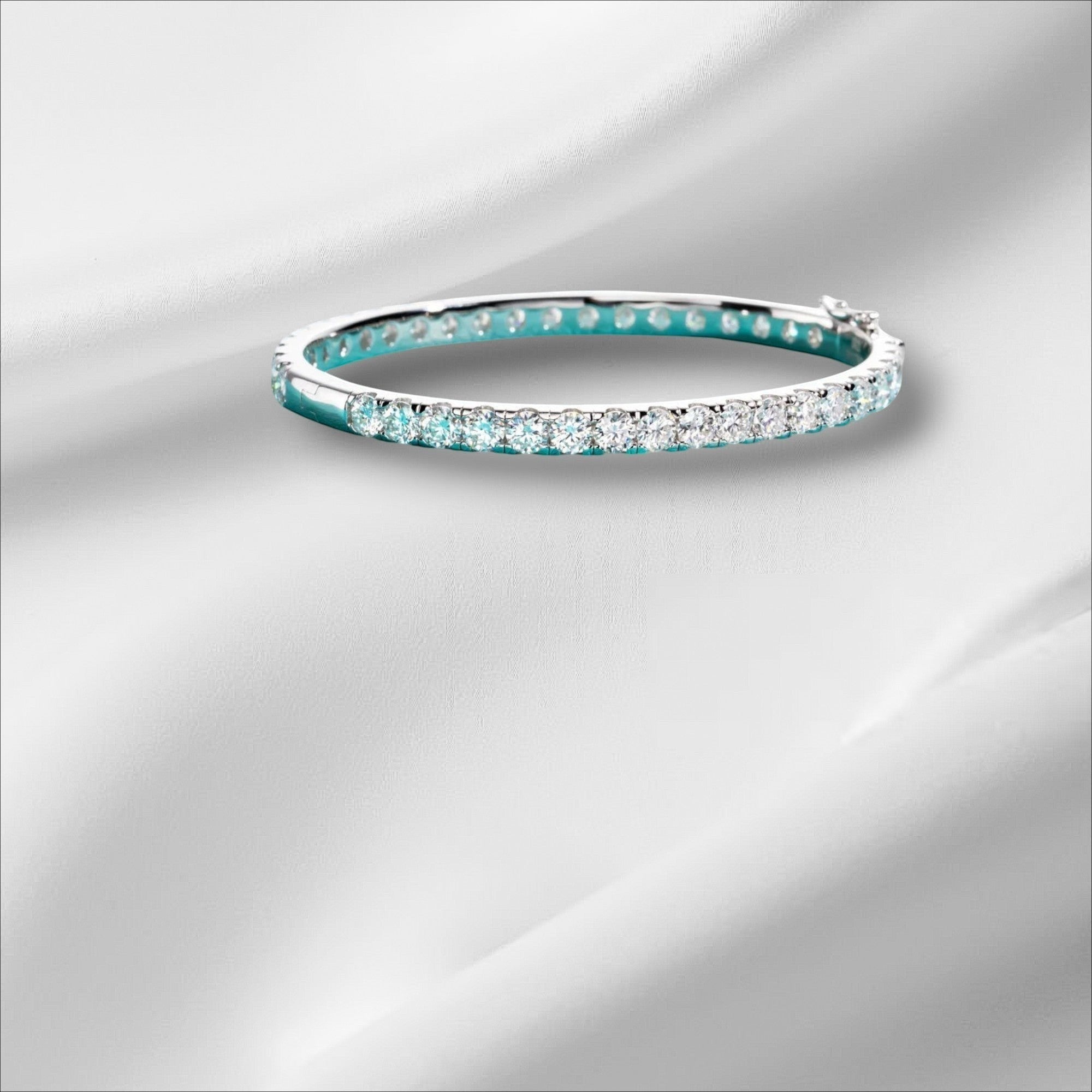 Bee-Bee's 11.7ctw Moissanite eternity bangle in sterling silver with 18k white gold plating. Features 4mm round-cut stones.