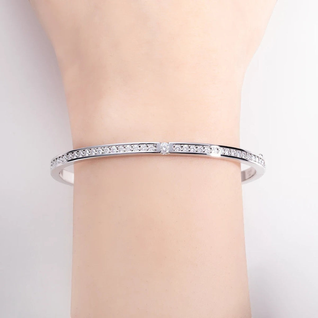 Bee-Bees 2ctw Moissanite eternity bangle in sterling silver with 18k white gold plating. Features D VVS1 stones and GRA certification.