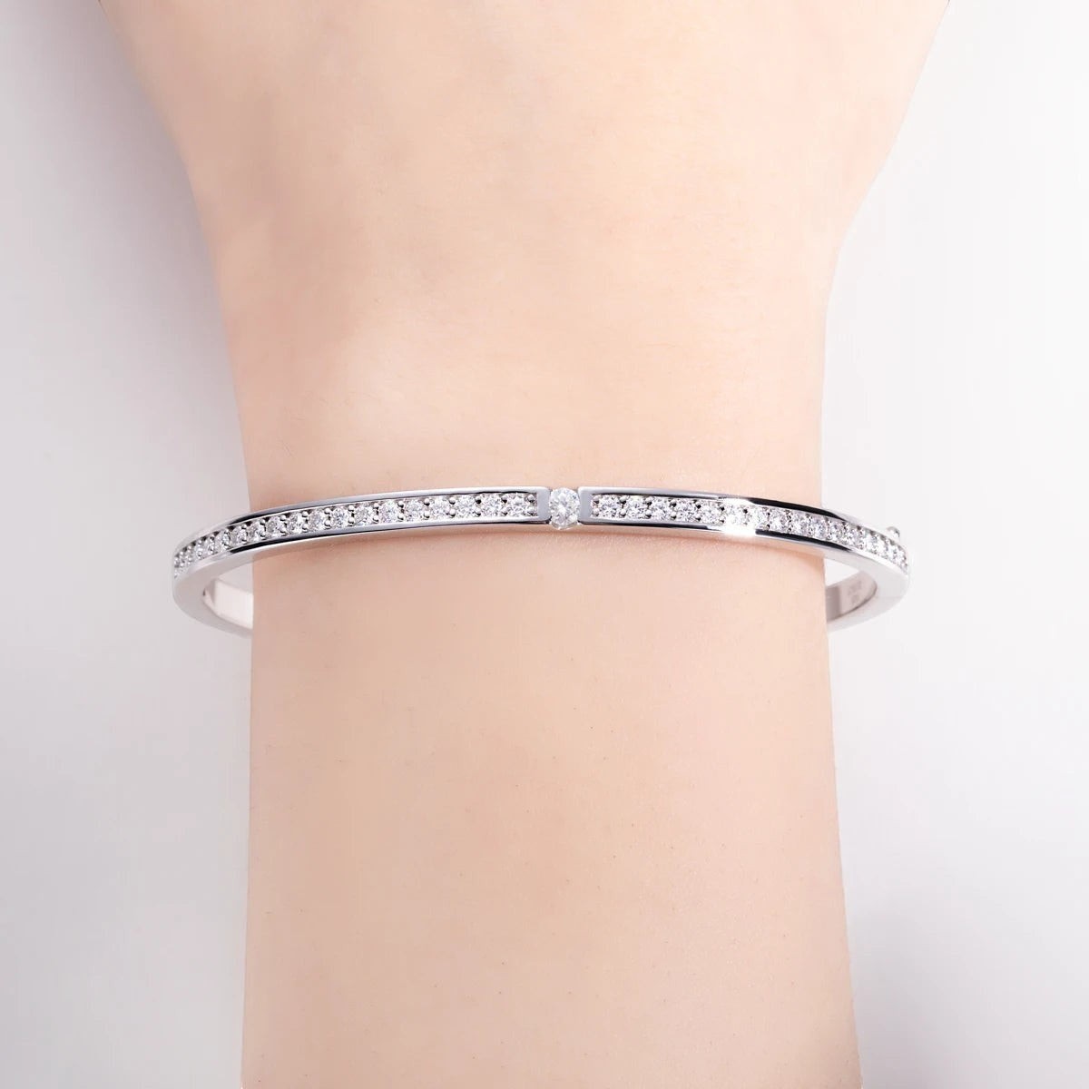 Bee-Bees 2ctw Moissanite eternity bangle in sterling silver with 18k white gold plating. Features D VVS1 stones and GRA certification.