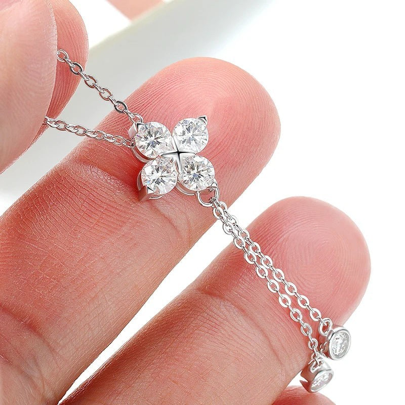 Bee-Bees dainty 4mm moissanite flower pendant necklace in s925 sterling silver held between fingers