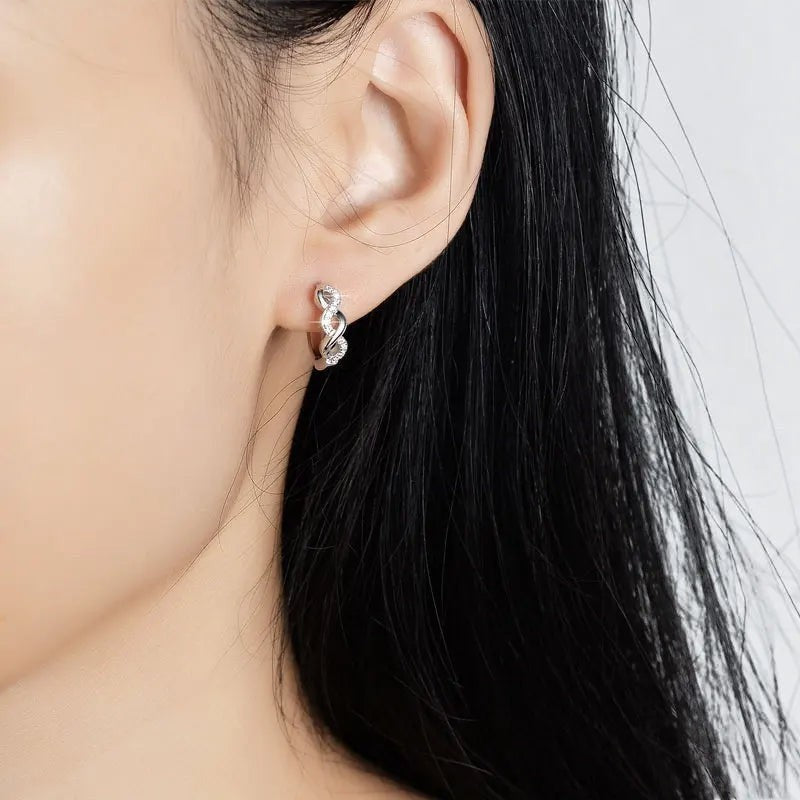 Bee-Bee's white gold plated sterling silver moissanite hoop earrings with infinity design.