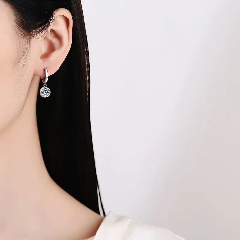 Bee-Bee's sterling silver hoop earrings with a single round moissanite pendant, D color VVS1 clarity.