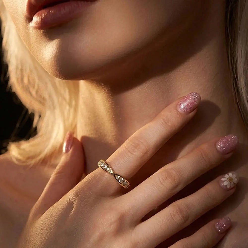 Bee-Bees sterling silver moissanite eternity band ring worn on a woman's finger with sparkling glitter nail polish