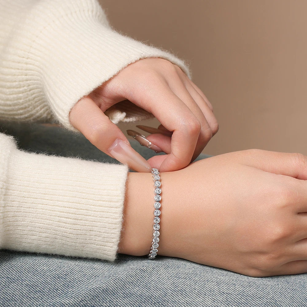 Bee-Bees 3mm round-cut D color VVS1 moissanite tennis bracelet in 925 sterling silver worn on a woman's wrist.