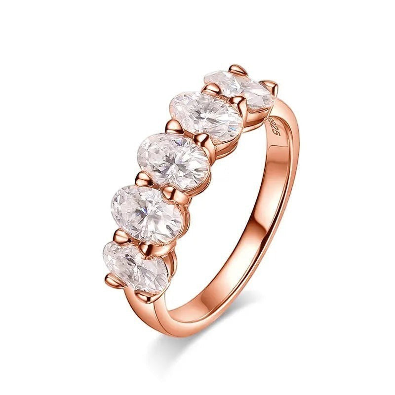 Bee-Bees rose gold eternity ring with five 4x6mm oval D color VVS1 moissanite stones in a prong setting.