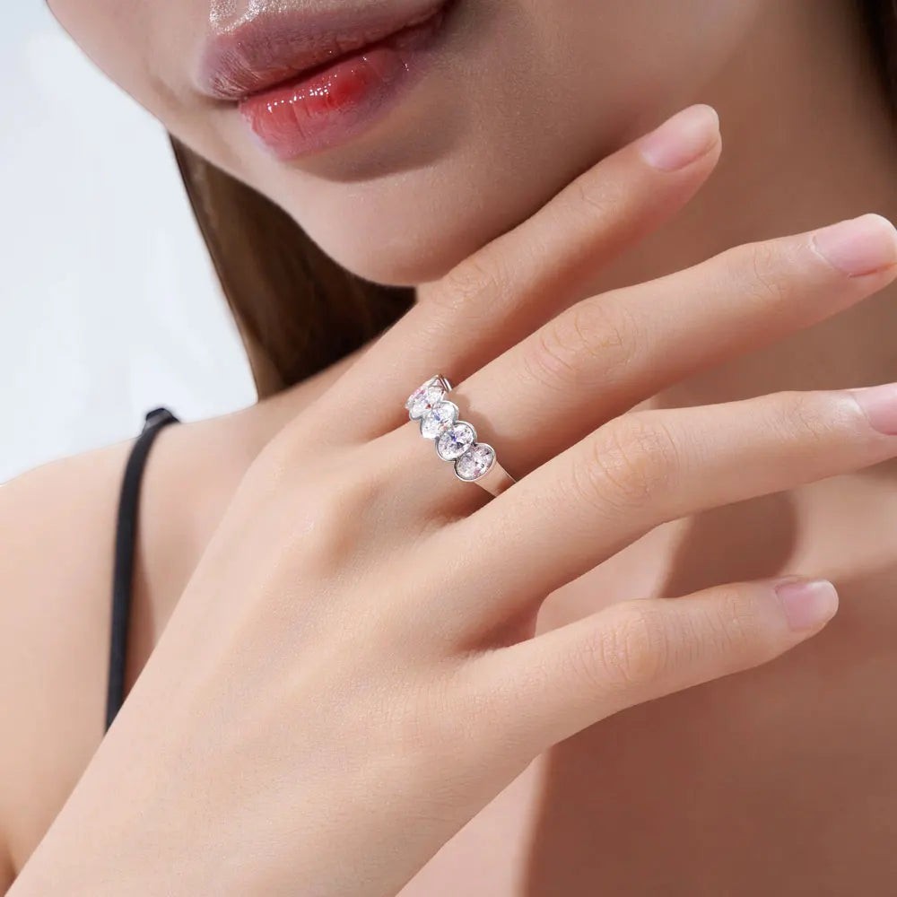 Bee-Bees 0.5ct oval moissanite eternity band in 18k white gold plated sterling silver worn on a woman's finger